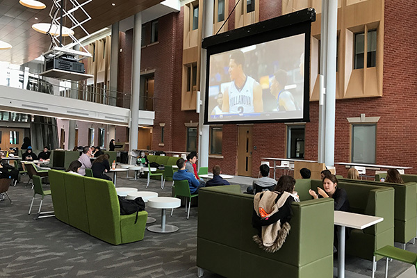 PCSB students, faculty, and administrators gather in the Palmisano Atrium for the PC Men's Basketball game watch.