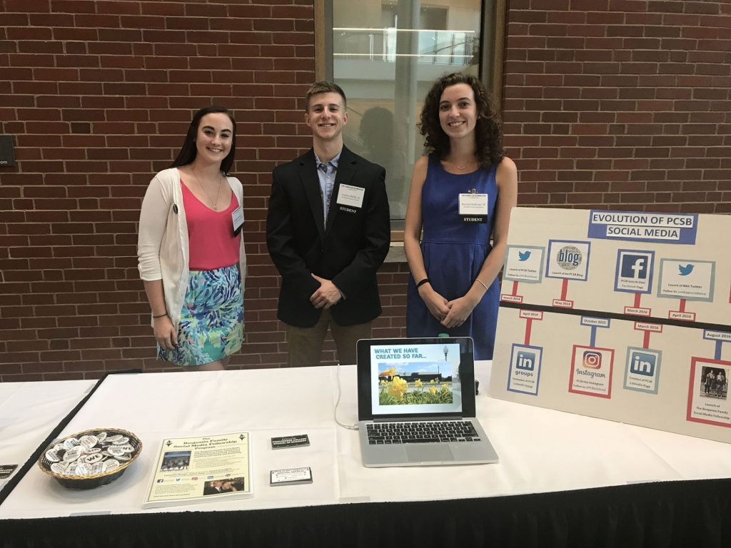Social Media Fellows Bridget Reilly '20, Austin Kulig '19, and Rachel Sullivan '18 pose with their booth at the Our Moment Showcase.