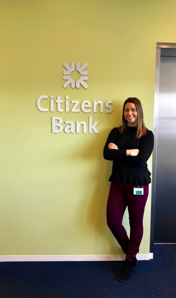 Aliza in front of a Citizens Bank sign.