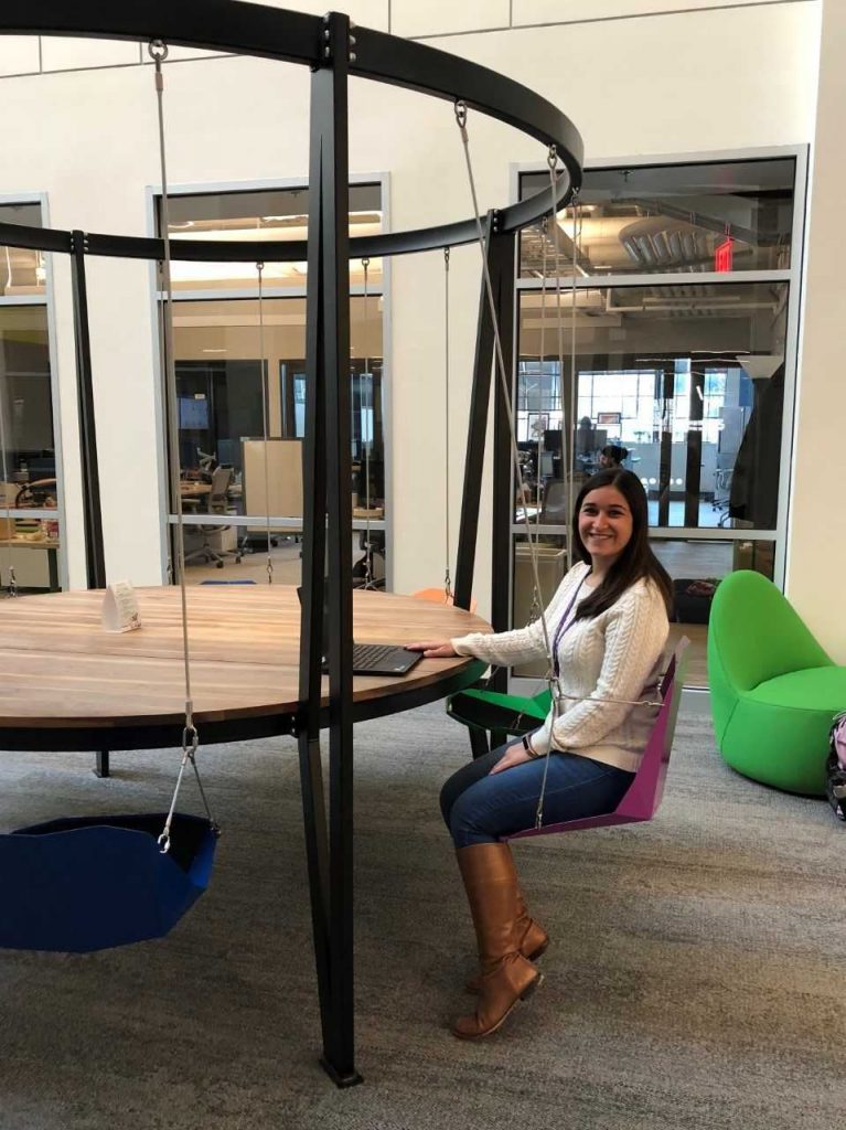 Lauren sitting in a hanging chair in her athenahealth office.