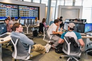 individual students, looking at computer screens, in a finance lab with Bloomberg terminals