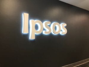 "I P S O S" written in large white letters hanging on a black wall