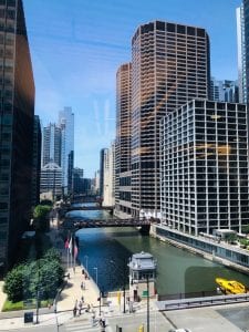 city skyline in front of a body of water on a clear, sunny day