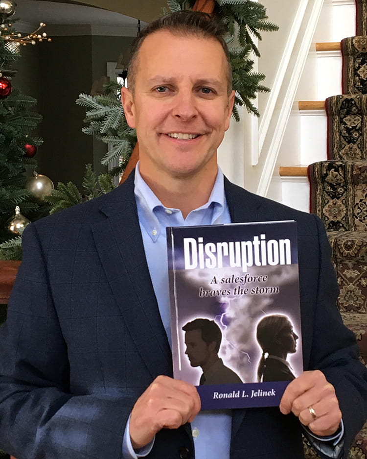 Ron Jelinek, marketing professor at Providence College, holding his new book entitled Disruption.