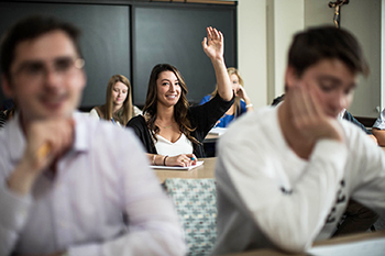 A student raises her hand during class.