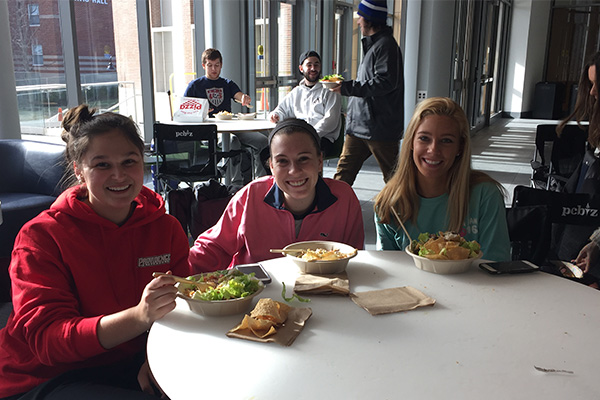 Students enjoying lunch from Qdoba Mexican Grill at the PC Men's Basketball game watch.