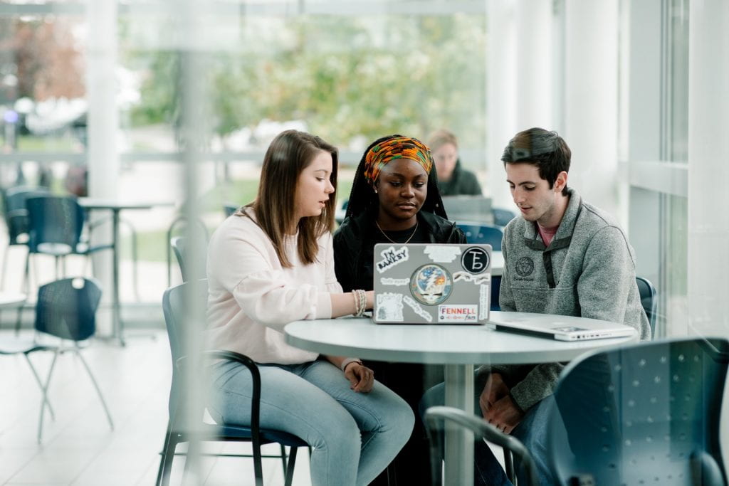 Students at table looking at laptop computer