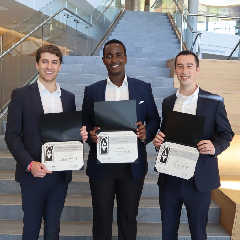 Three males in suits holding certificates