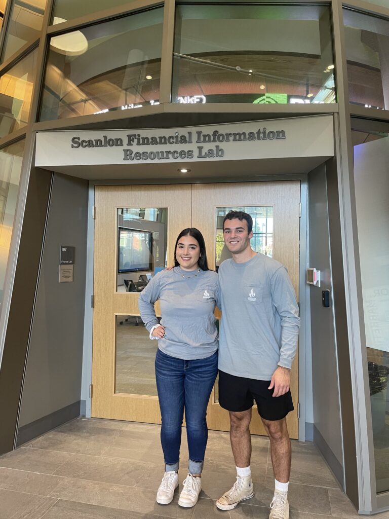 Christina Savo and Alex Wheeler standing in front of Scanlon Financial Information Resources Lab