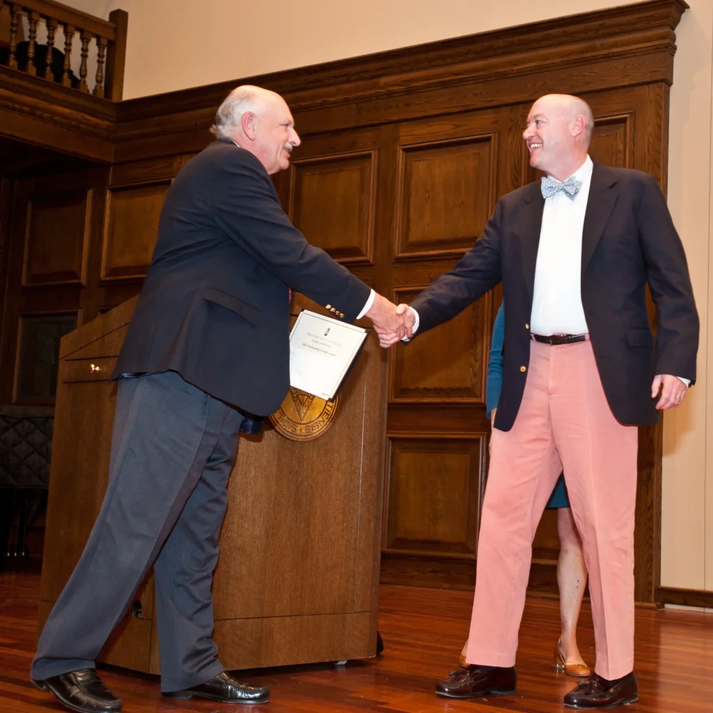 John Schibler, Ph.D., of management shakes hands with Matthew Callahan, M.A. of finance