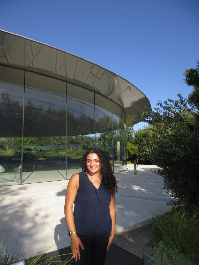 Penelope Tejada in front of the Apple building at her summer internship in a navy blue sleeveless blouse.