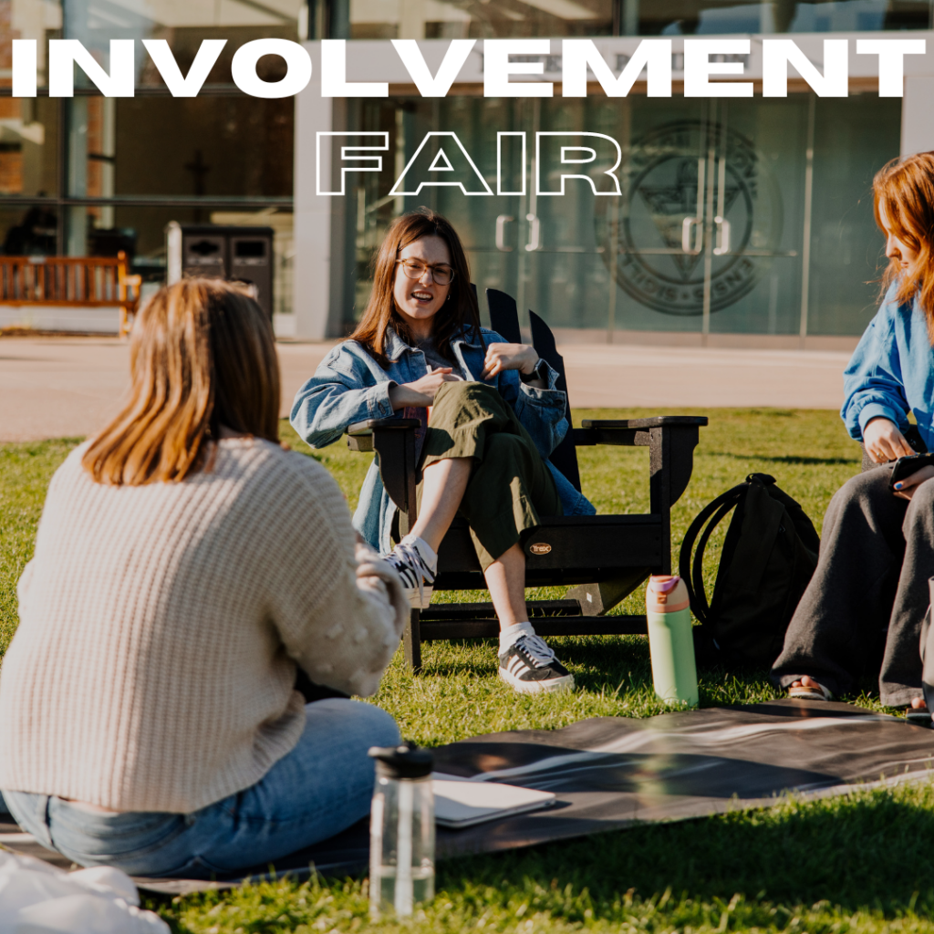 Photo of three women sitting on Slavin Lawn with the text "involvement fair" at the top