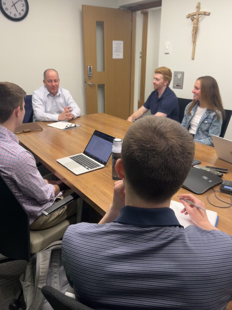 Five people seated at a conference table, Kevin Haverty at the head of the table